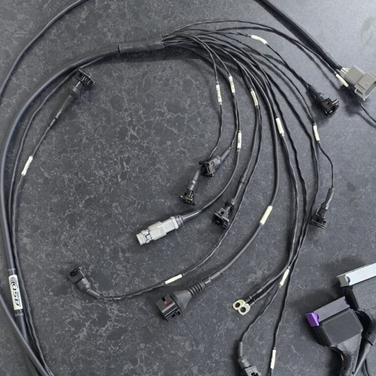 A Concentrically Twisted wiring loom laid down on a bench, demonstrating what's involved in a custom wiring loom like this.